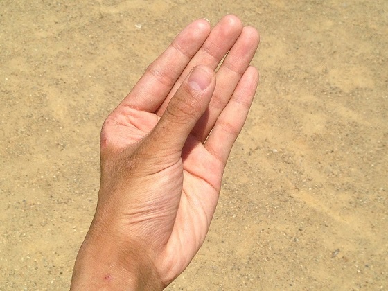 Мелкий песок в руке практически не заметен